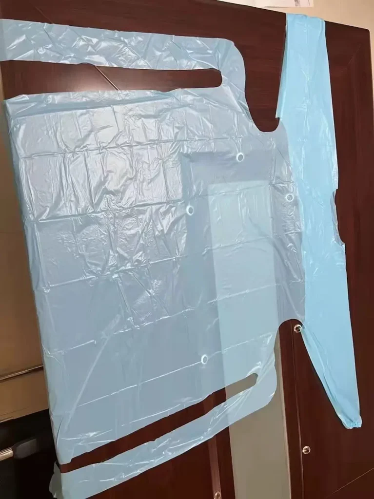 Medical grade isolation gown with elastic cuffs and below-knee length for infection control